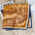 Mustard yellow paisley silk scarf with navy contrast border styled on a khaki coat - Khaki/Earth Yellow
