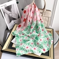 Detail of pink and mint green silk scarf with daisy pattern draped on a handbag - Green (70FJ373-4)