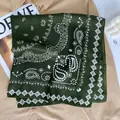 Close-up of silk green square scarf with white Paisley pattern on a khaki shirt - Green
