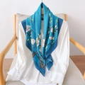 Dettaglio di sciarpa in seta con stampa realistica di fiori di magnolia su tessuto azzurro - 90cmx90cm / Blu