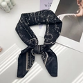 Detail of vintage paisley silk scarf tied in a bow with classic key and chain patterns - Beige