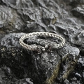 Vintage braided titanium steel bangle with double tiger heads on dark rock background - Steel Color