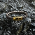 Bracciale da uomo in pelle intrecciata con fibbia in metallo dorato su sfondo di roccia - Fibbia Oro