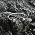 Minimalist silver twisted cable stainless steel open cuff bracelet on black stone background - Steel Color
