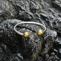 Twisted stainless steel open cuff bracelet with gold-tone accents on a stone background - Gold Style