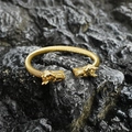 Gold twist bangle featuring dragon head ends on a dark stone background - Gold Style