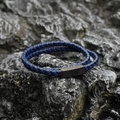 Doppelt gewickeltes Herren-Lederarmband mit schwarzem Magnetverschluss auf einem Felsen - Blau