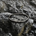 Minimalist matte dark grey titanium steel bangle shown on a textured rock surface - Frosted Small Style / Black