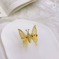 Exquisite goldene hohle Schmetterling-Haarklammer auf weißem Keramiktablett - Gold
