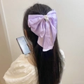 Elegant purple satin bow hair clip with faux pearls worn on long hair for a sweet style - Purple