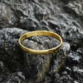 Minimalist gold titanium steel bangle with a polished mirror finish on a dark stone background - Bright Large Style / Gold