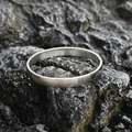 Sleek silver stainless steel minimalist bracelet with a brushed matte finish on dark rock - Frosted Large Style / Steel
