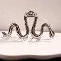Pince à cheveux serpent en métal argenté avec finition miroir polie sur socle ondulé - Noir