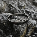 Minimalist matte black titanium steel bangle with brushed texture on dark rock - Frosted Large Style / Black