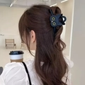 Graziosa clip per capelli a forma di gatto nero indossata in un contesto naturale - Nero