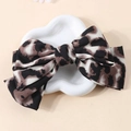 Detail of leopard print bow hair clip on a decorative white tray with soft lighting - Chocolate Leopard Print