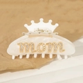 Dettaglio molletta a corona bianca con scritta MOM in strass su carta beige - Stile MOM