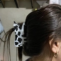 Cute black and white cow print hair claw clip shown on long dark brown hair - Cow Print