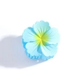 Gros plan sur une élégante pince à cheveux fleur bleu clair et jaune au fini mat soigné - Bleu