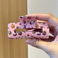 Detail of pink glitter Halloween hair claw with ghost and pumpkin pattern hand-held view - Halloween Ghost / Pink Glitter Halloween Ghost Style (1)