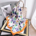 Floral faux silk square scarf with purple and green patterns draped on a handbag - 70x70 / Orange