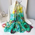 Detail eines seidigen langen Schals mit bunten Blumendrucken über einer weißen Bluse - XSD294-4 Grün