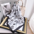 Detail of silk-like floral checkerboard square scarf styled on a white designer handbag - 70x70 / Dark Grey