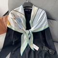 Detailweergave van een zijden sjaal met paardenpatroon, gestyled met een zwarte trui en bril - Lichtblauw
