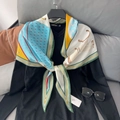 Diamond-shaped silk scarf with orange horse pattern and green stripes on black sweater - Green