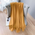 Close-up of lightweight yellow linen scarf draped on a grey armchair in home setting - Extended Version / Turmeric