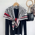 Detalle de un pañuelo de seda con patrón geométrico con top negro y bolso de cadena - Rojo Gris