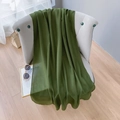Detailed macro view of olive green linen scarf draped over a chair with stylish accessories - Extended Version / Army Green