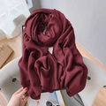 Close-up of dark burgundy linen-cotton scarf texture draped on a gray fabric chair - Extended Version / Dark Red