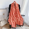 Châle en soie rouge et or avec motifs floraux et bordure noire sur une chaise vintage - Rouge Orangé