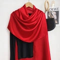 Close-up of red silk satin shawl on a wooden hanger with elegant glossy texture - Red