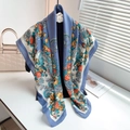 Nahaufnahme des blauen Schals mit Rosen- und Paisleymuster auf einem Displayständer - Aqua