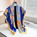 Detail van een zijdeachtige bloemen sjaal in blauw en oranje hangend aan een zwarte hanger - Groot Vierkant / Blauw