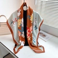 Detail van een zijden sjaal met bloemenprint in karamel en mintgroene tinten - Groot Vierkant / Baksteenrood