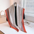 Dettaglio di un grande foulard geometrico con strisce nere e bordo arancione vivace - Rosso Mattone