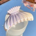 Shell-shaped iridescent gradient hair claw clip in yellow and pink on a white cup rim - Fishtail-2 (Iridescent Yellow Pink Purple Gradient)