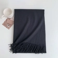 Detail of black cashmere-like scarf showing dense fringe texture and minimalist Nordic style - 185x70cm / True Black
