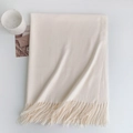 Detailed close-up of cream pashmina scarf with elegant fringe trim on white surface - 185x70cm / Pure White