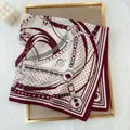 Detail of burgundy equestrian chain print scarf on a tray with decorative elements - Red
