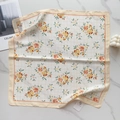 Detailed flat lay of a floral square silk scarf featuring orange blossoms on beige plaid - Yellow Grid Orange Floral (58FJ94-4)