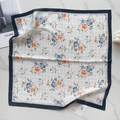 Flat lay of silk-like floral square scarf with blue borders on marble background - Blue Edge Grid Floral (58FJ94-1)