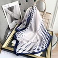 Marineblauer gepunkteter Seidenschal an beiger Handtasche in eleganter Raumszene - 70x70cm / Blau