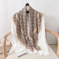 Fashionable geometric print silk scarf in khaki and black draped over a white shirt - 90*90cm / Tan