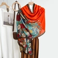 Elegante feloranje sjaal met vintage bloemenprint gedrapeerd op een houten hanger - 180x85cm / Oranjerood