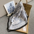 Close-up of elegant blue and grey floral silk scarf tied to a camel leather handbag - Off-white