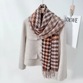 Brown and orange houndstooth scarf with fringe tassels displayed on a coat - Maillard Brown